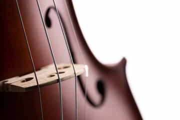 A violin or viola with four strings with a beautiful soft light hitting it on a white background....