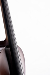 A violin or viola with four strings with a beautiful soft light hitting it on a white background....