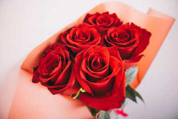 Beautiful bouquet of red roses on a white background with green leaves
