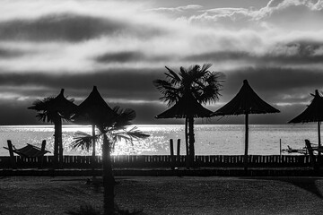 abandoned beach out of season, black and white with the sunset