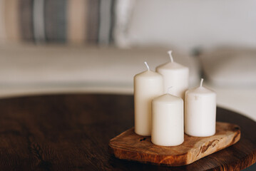 Fototapeta na wymiar Candles in cozy interiors as element of hygge design and atmosphere. Coziness, holidays and family time