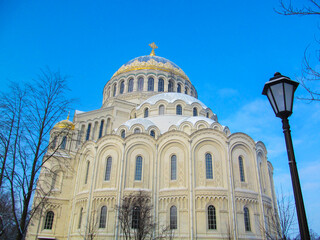 Fototapeta na wymiar The Naval Cathedral of Saint Nicholas (Marine Cathedral) in Kronstadt, St. Petersburg, Russia on a winter day. Beautiful building with the illuminated sun against the blue sky.
