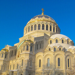 Fototapeta na wymiar The Naval Cathedral of Saint Nicholas (Marine Cathedral) in Kronstadt, St. Petersburg, Russia on a winter day. Beautiful building with the illuminated sun against the blue sky.