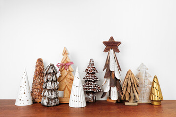 Rustic wooden Christmas tree decor on a wood shelf against a white wall background