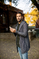 Fototapeta premium Young man using mobile phone in the park