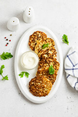 Chicken patties on white dish with yogurt sauce. Top view, space for text.