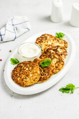 chicken fritters on white dish with sour cream sauce. Top view, space for text.
