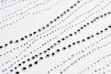 Perforated pattern on surface of paper. Close-up texture