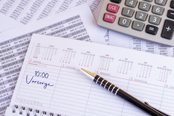 Terminkalender auf einem vollen Schreibtisch mit einem Eintrag 10 Uhr Vorsorge