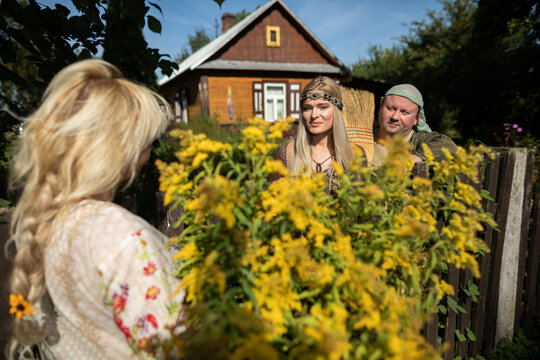 Neighbors Cheerfully Talking Over The Fence. A Basket Full Of Goldenrod Herbs.