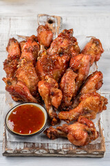 Chicken wings with sriracha sauce on wooden table