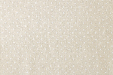 Light beige fabric with white polka dots. Tablecloth with polka dots. Background.