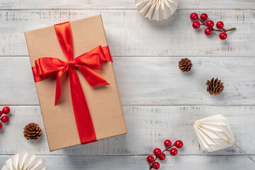 Brown craft gift box on wooden background. Gift box with red ribbon on wood background with space.