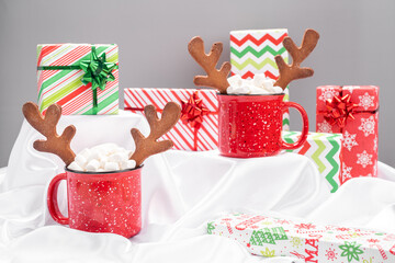 Red mug with hot chocolate, gingerbread reindeer horn cookies and marshmallow
