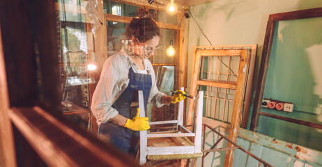 Fototapeta na wymiar Young woman wearing apron working in the workshop