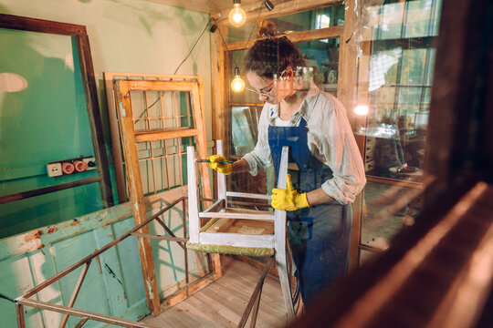 Young woman wearing apron working in the workshop