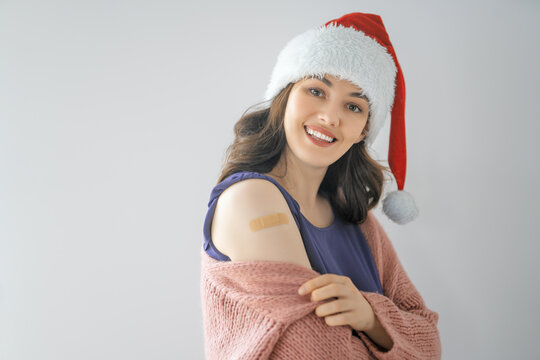 Young woman after vaccination wearing Santa hat
