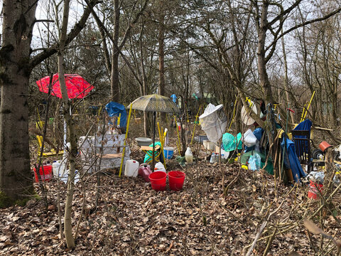 Environment pollution - colorful plastic garbage and umbrellas in a small forest in autumn