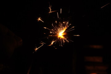 A burning sparkler on the black