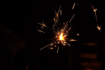 A burning sparkler on the black