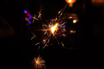 A burning sparkler on the black