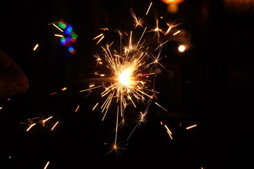 A burning sparkler on the black