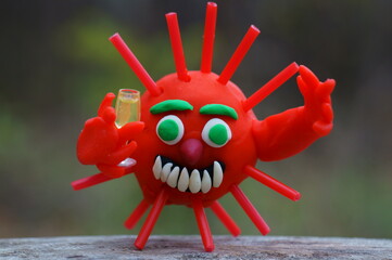 A figurine of a virus with a glass of champagne in his hand.