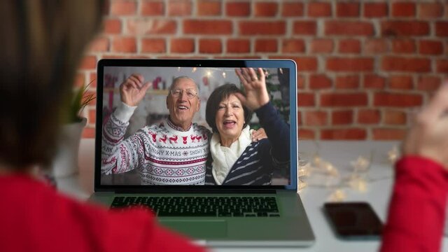 Grandparents in a video call conference with their daughter at Christmas time. Happy family, social distancing.