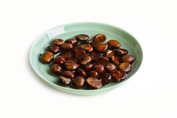 Ripe chestnuts on a plate, sharpened in water. Healthy food. Isolate. Photo