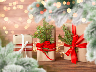 Christmas postcard gifts on a wooden table, garland with fir branches. Defocus.