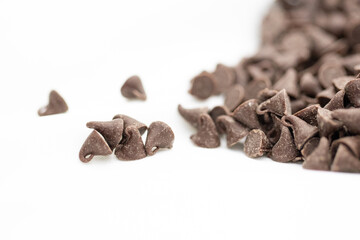 Close up of mini chocolate chips for baking cookies or snacks in white background.