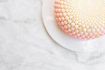 Interesting mousse cake on a white marble background. Delicious and beautiful pastries.