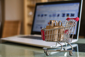 Shopping online. Recyclable Paper Bag In A Shopping Cart On A Laptop Keyboard. Shopping Service On...