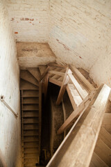 Fototapeta na wymiar Spiral wooden staircase in a stone building.