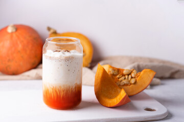 Pumpkin spice latte in a glass, seasonal autumnal coffee drink.