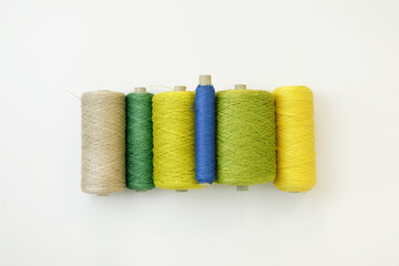 Set of cord in shades of green, retro .thread on spool on white background, flat lay. Equipment to creative DIY hobby hand works like embroidery. Colourful string, yarn on the roll.