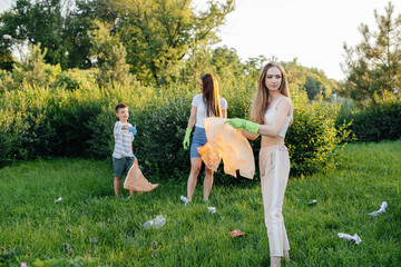 A group of girls with children at sunset are engaged in garbage collection in the park....