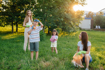 A group of girls with children at sunset are engaged in garbage collection in the park....