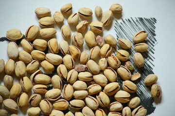 Top view of Pistachio nuts in wooden bowl on checkered cloth. High quality photo