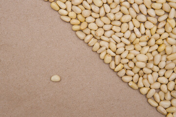 Pine nuts on a plain craft background. The concept is one against all.