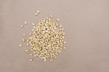 Peeled pine nuts are heaped on kraft paper