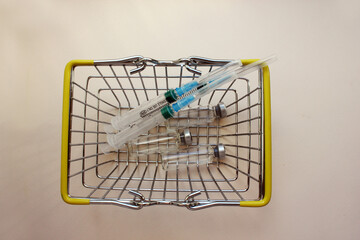 Basket with ampoules of medicines for injection, syringe. vaccination. The concept of medicine and immunity. Vaccination against viral infections. Drug and injection. cold. Injection, drug. Flatly