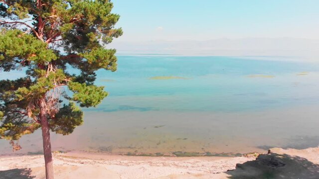 Aerial panning view scenic blue lake panorama with horizon outdoors. Armenia Sevan lake coastline . Relaxation holiday in caucasus