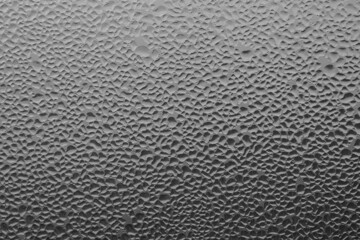 Raindrops on the window pane on a gray background. Natural pattern of raindrops. Texture for creativity. Water on the surface of the glass.