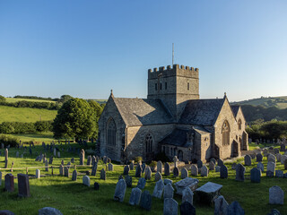 Small old church at Avon cemetery. Gravestones on green grass in Avon Gifford St Andrew's Church Devon, UK. Drone aerial view