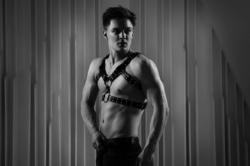 Black and white portrait muscular sexy guy in a harness.