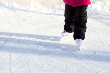 Children's Plastic Sliding Skates with Size Adjustment close-up on Ice in Winter outdoor. Rolling and sliding in frosty sunny day, active winter sports and lifestyle