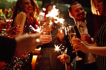 Sparkling sparklers in the hands. Playing firework to celebrate winter holidays with friends at the...