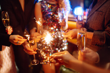 Sparkling sparklers in the hands. Playing firework to celebrate winter holidays with friends at the party. Magic New Year, Christmas.