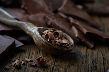dark chocolate over wooden backround with some cocoa powder